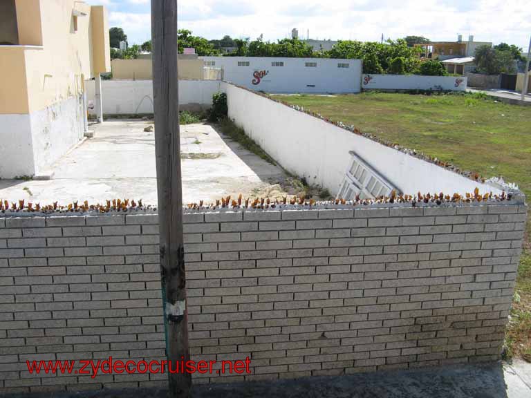 068: Carnival Fantasy, Progreso, MX, Double Decker Bus Tour, broken glass bottles on top of fence